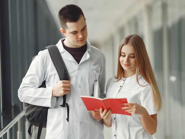 Medical students are reading a book in a hospital hall