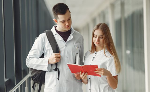 Medical students are reading a book in a hospital hall